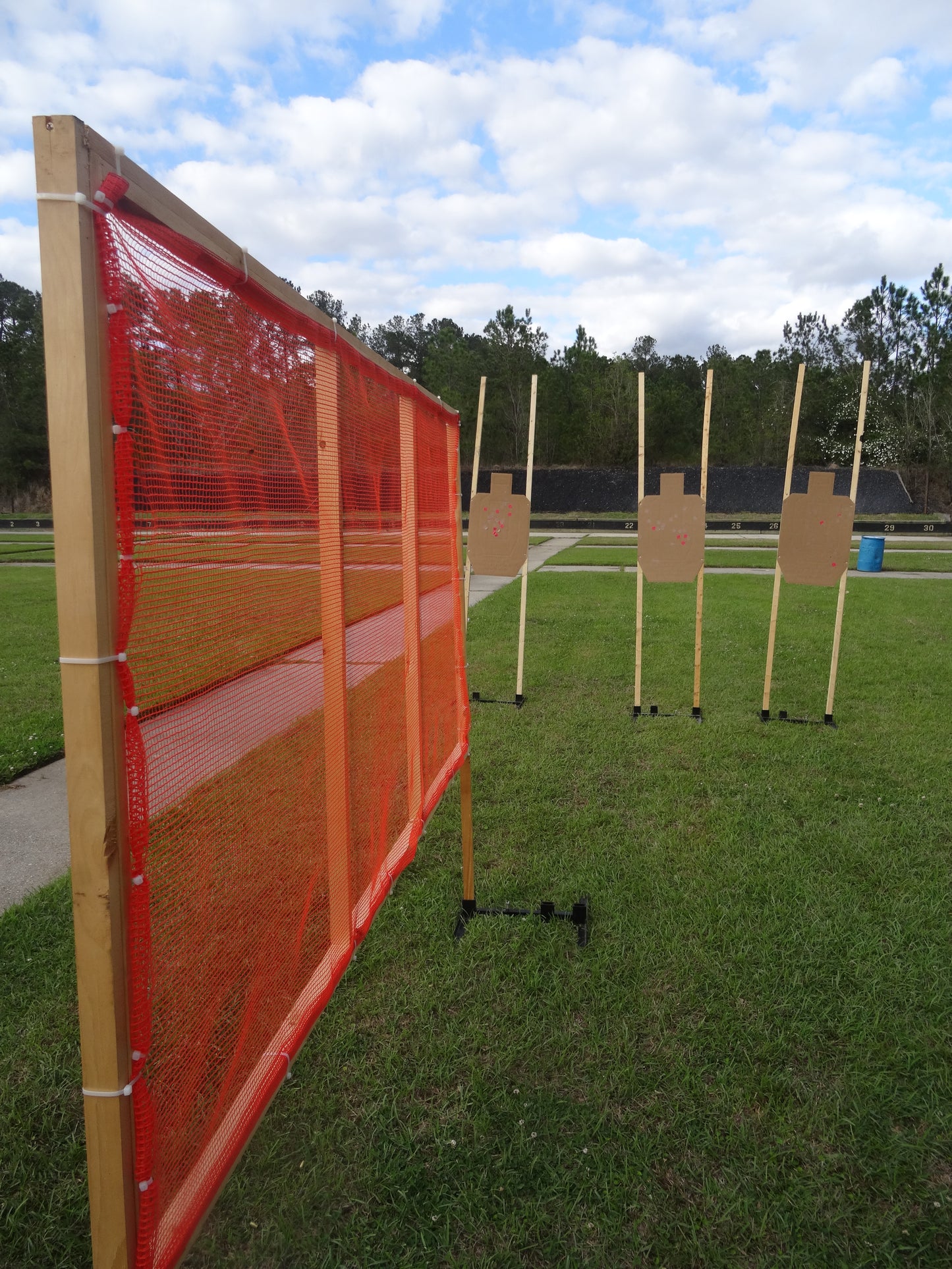 Close-up of orange shooting range barrier netting attached to frame